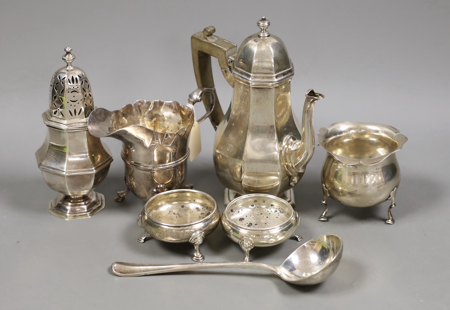 A George V silver octagonal hot water pot, a.f. and six other items of small silver including pair of salts, caster, cream jug, bowl and sauce ladle, 23.4oz.